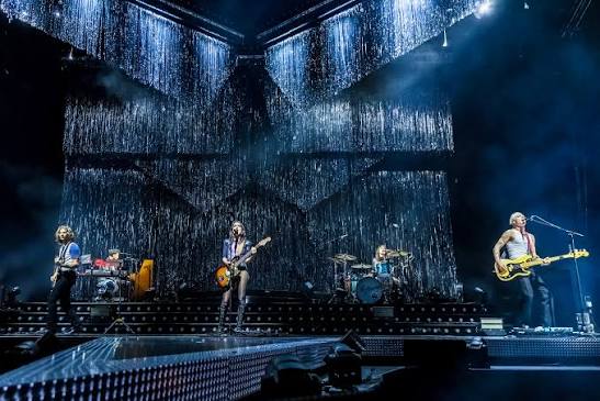 Wolf Alice performing together on a wide concert stage